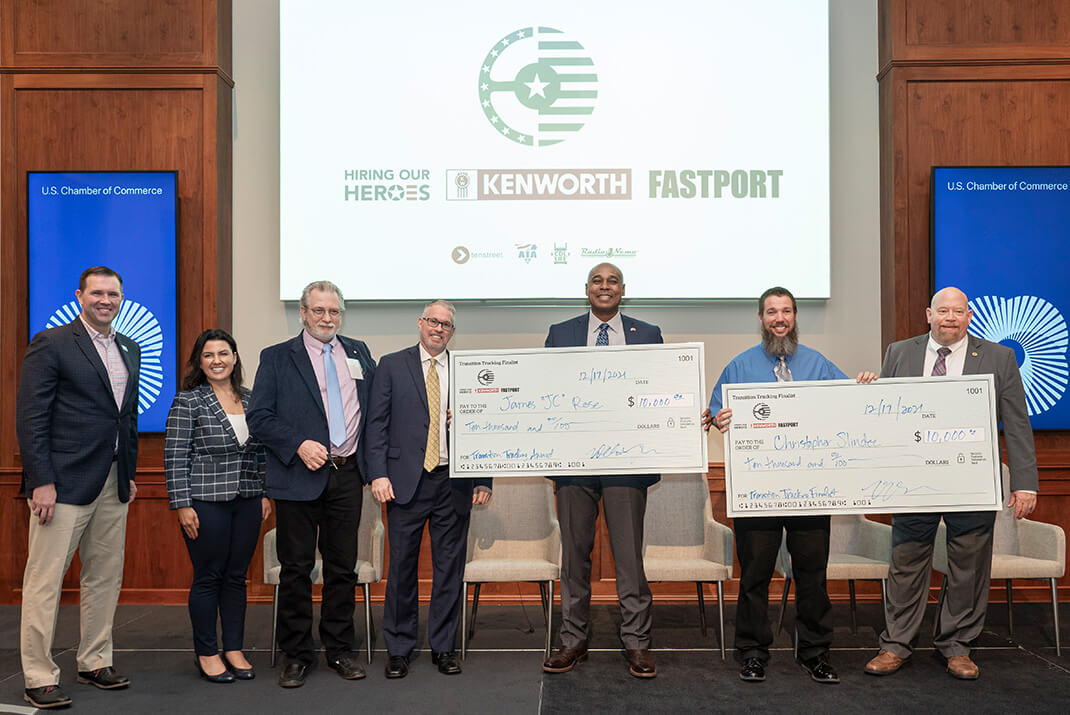 Image of 2021 Transition Trucking finalists and winner standing on stage holding large checks