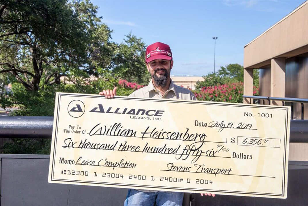 Image of William Heissenberg holding large check