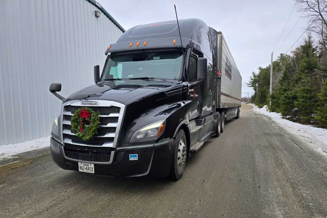 Image of a Stevens Transport truck with a wreath hanging from the front grill