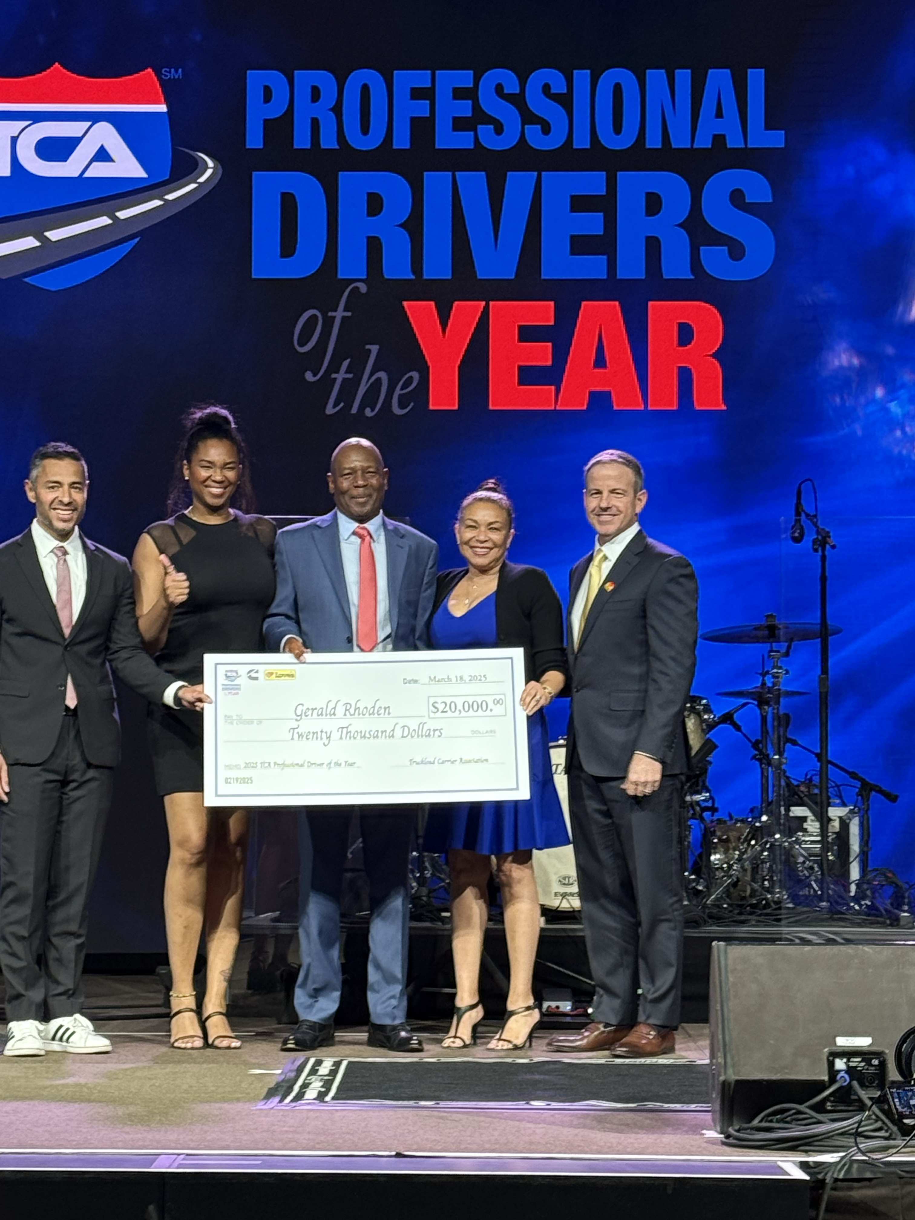 Image of Rhoden holding large check at TCA award ceremony
